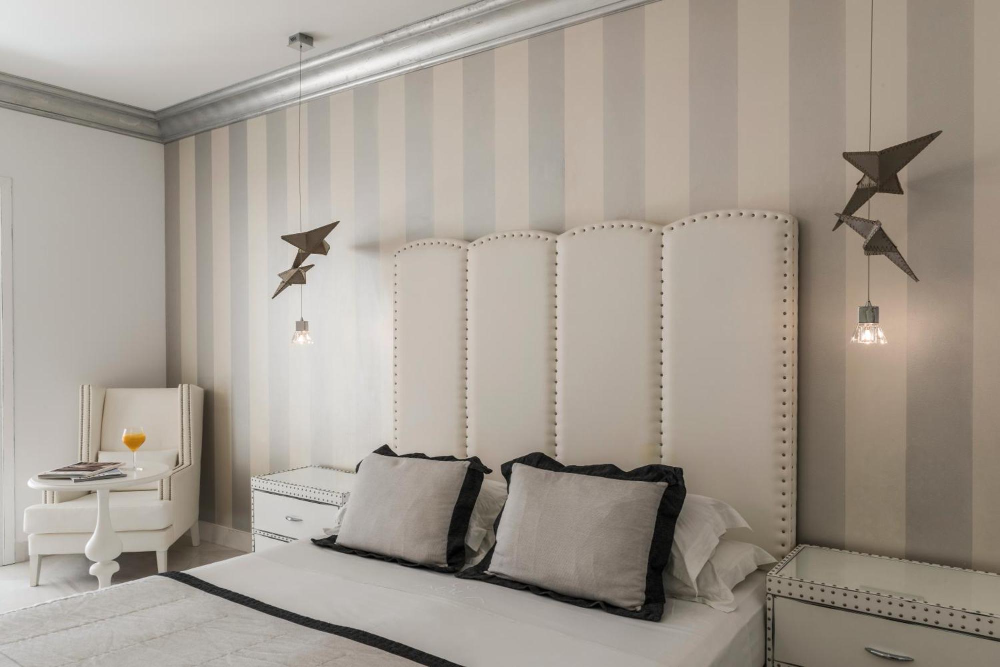 Mitsis Selection Alila Hotel Faliraki Ruang foto A bedroom with a bed, a nightstand, a chair, and a lamp