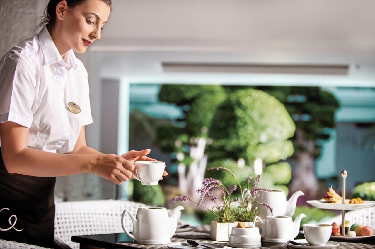 Mitsis Selection Alila Hotel Faliraki Bagian luar foto A flight attendant serving tea on board a plane